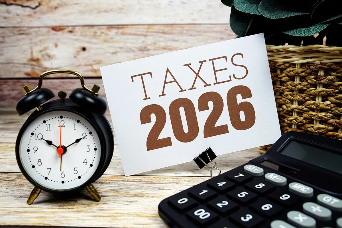 Standard Deduction 2026: The Numbers You Need to Start Planning 2 a sign that says taxes 2026 next to a clock and calculator.