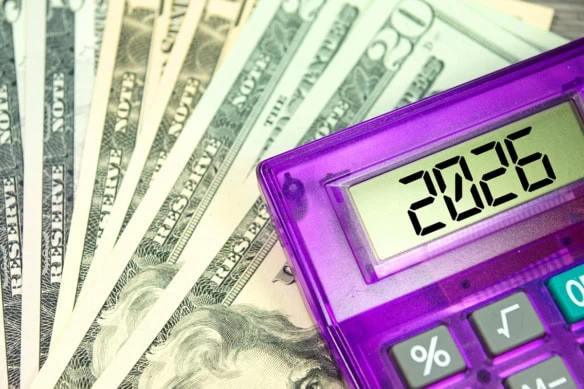 a calculator that says 2026 laid over a number of 20 dollar bills.