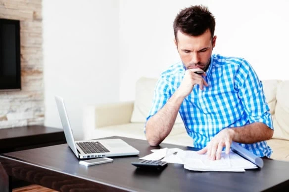 Young man reviewing form w-2 at home 1200