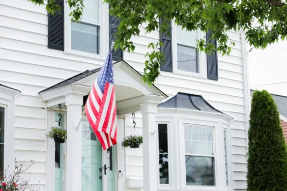 american flag hanging on front of house