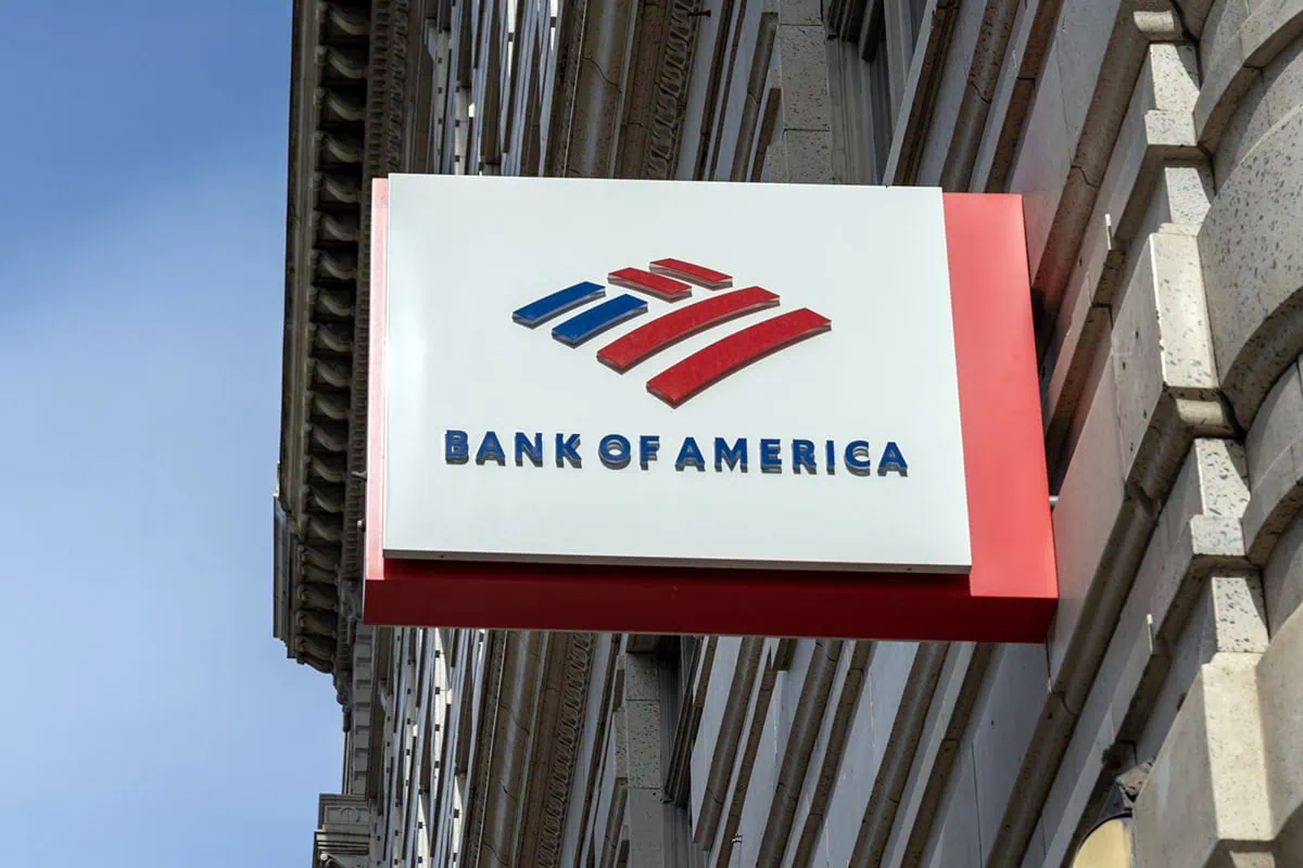 a small bank of america sign juts out of a city building.