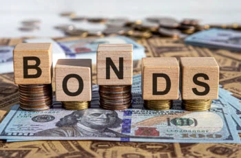 wooden blocks spelling bonds laid atop coins and cash.