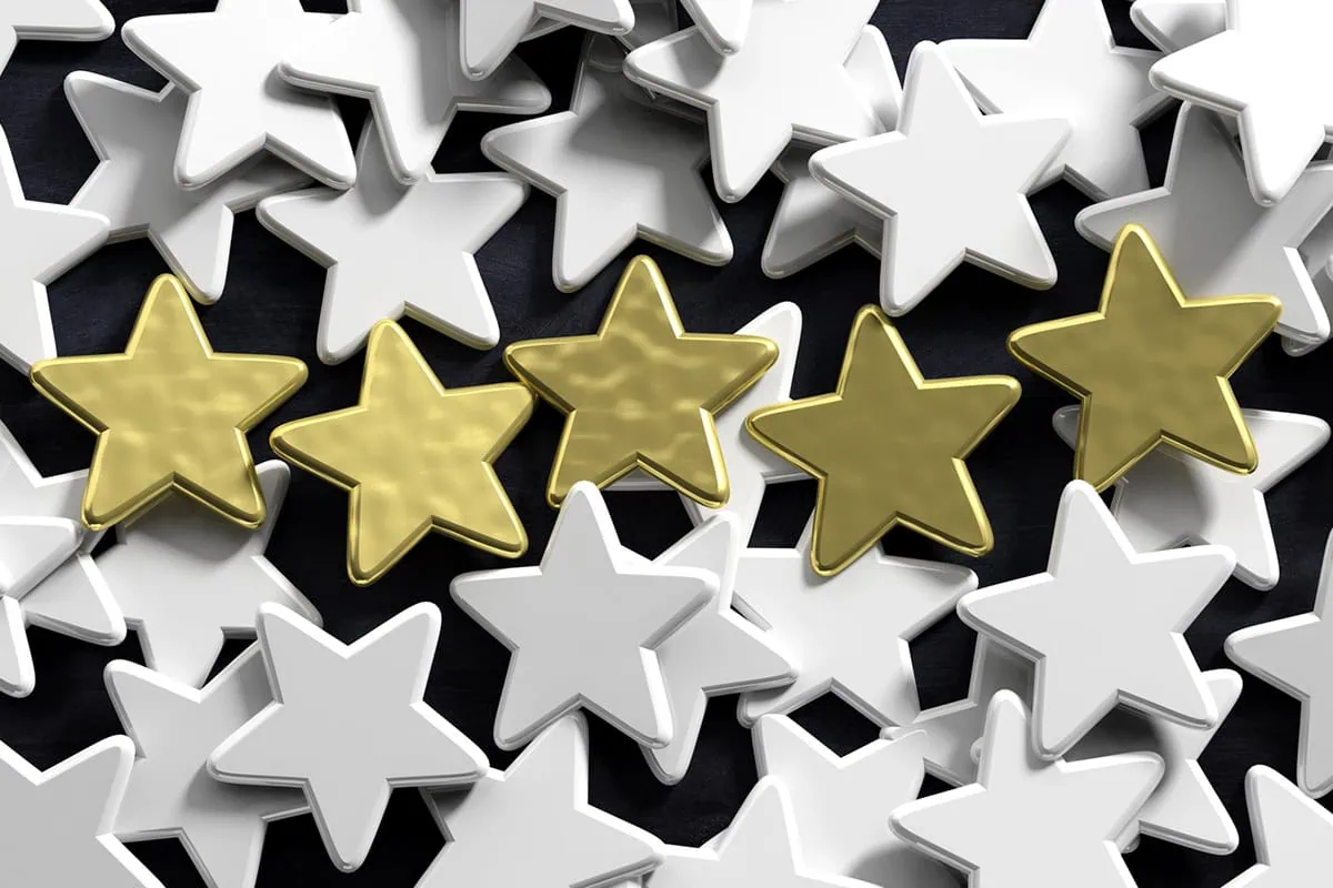 five gold stars stand out from many silver stars.