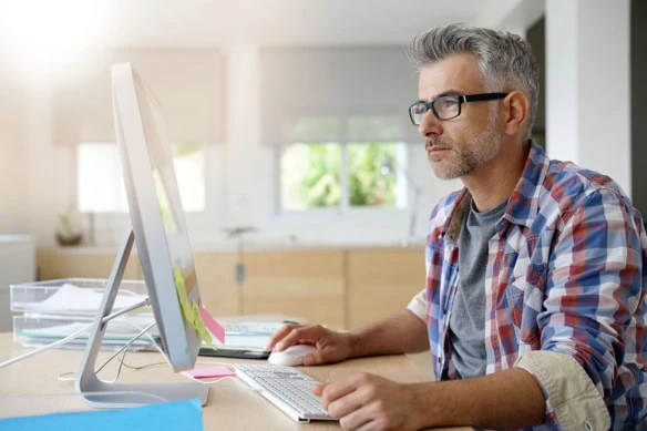 a middle-aged man uses the computer.