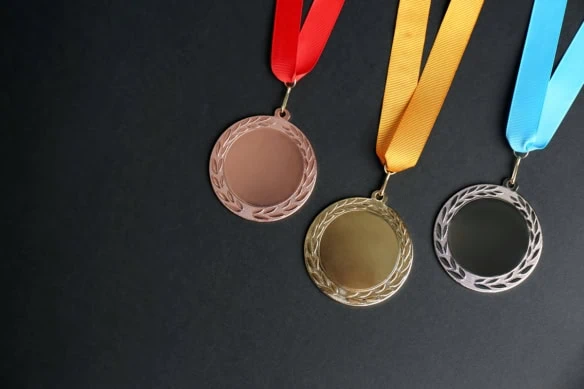 gold silver and bronze medals on a black background.
