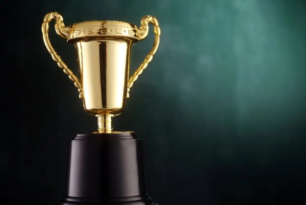a trophy sits against a green background.