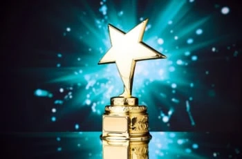 a gold star trophy against a green and black background.