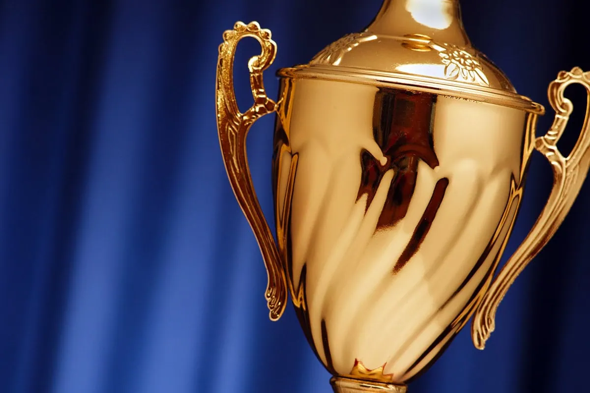 a close-up of a gold trophy against a blue background.