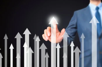 a businessman points to one of several white arrows pointing upward.