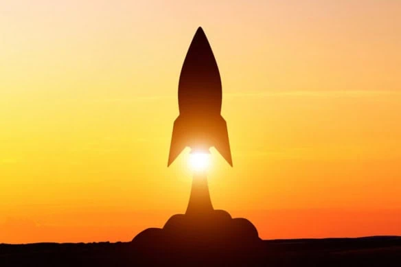 a rocket taking off at sunset.
