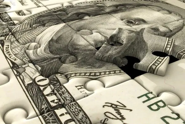 a dollar bill is cut into puzzle pieces.