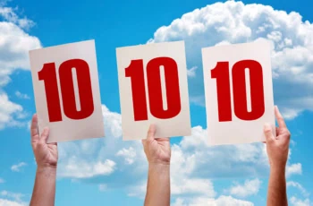 three people raise up score cards that say 10 indicating the highest possible score.