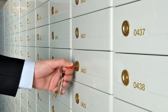a businessman opens a safe deposit box at a bank.