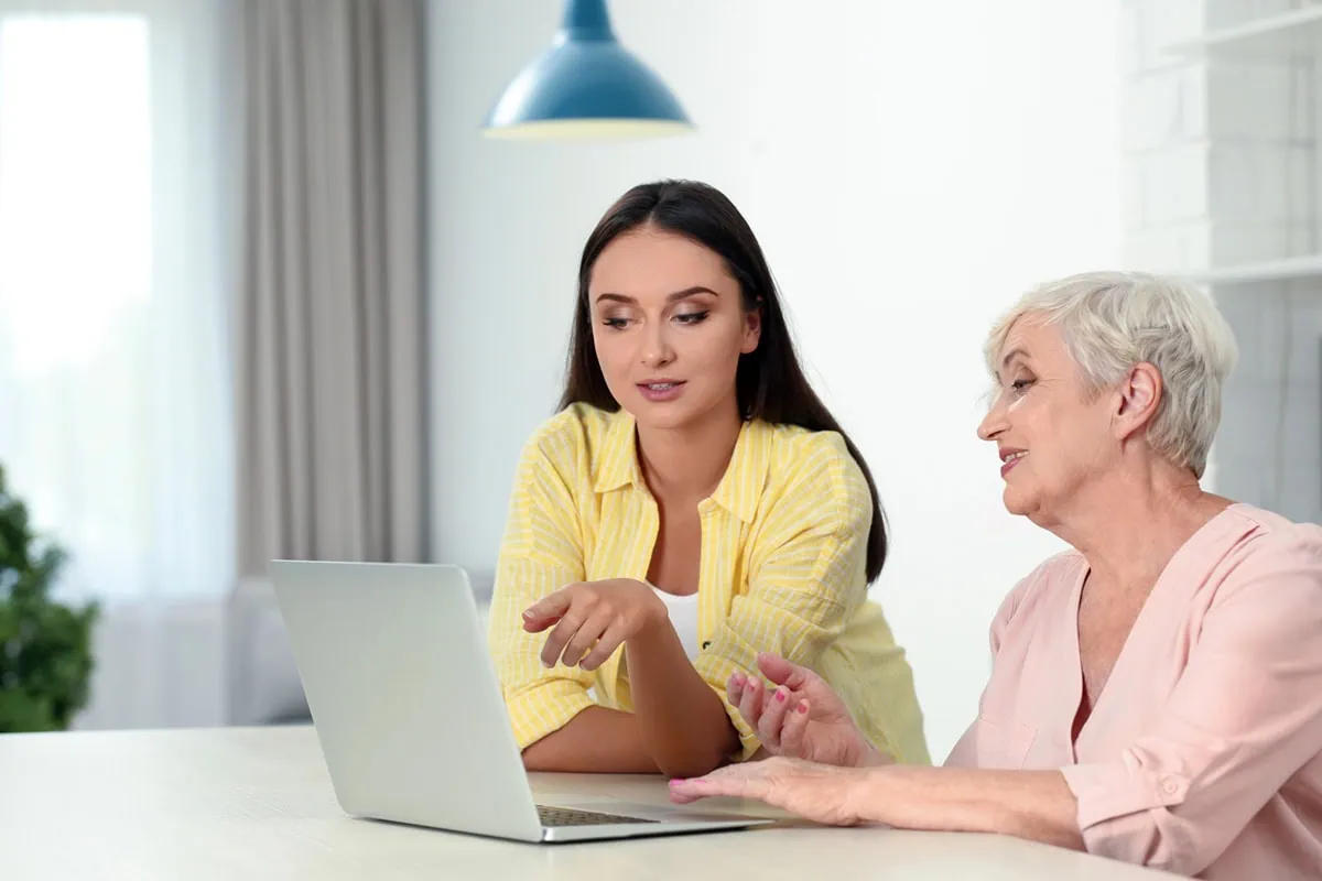 These 7 mutual funds keep it simple, smart 2 a young adult looks at her laptop with her senior mother.