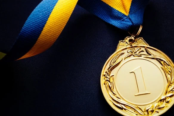 a gold medal with a blue and yellow ribbon.