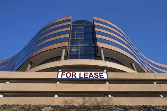 a large office building has a sign that says for lease.