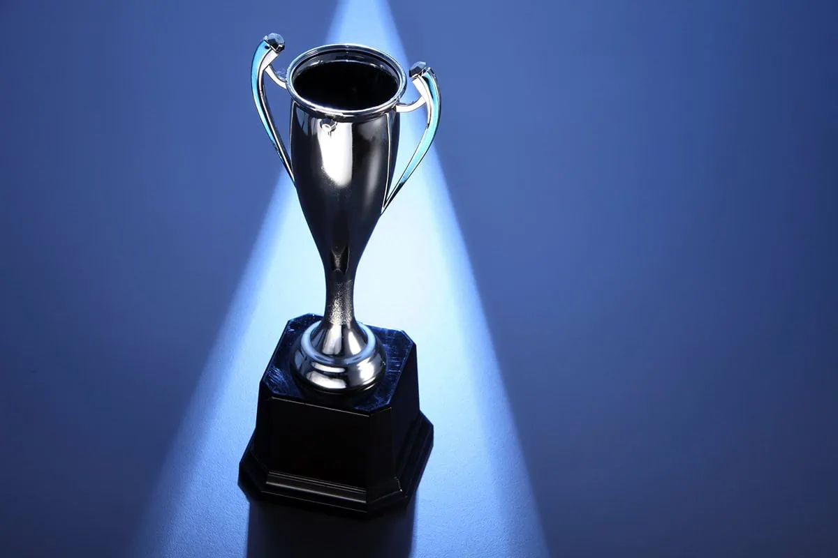 a silver trophy against a blue background.