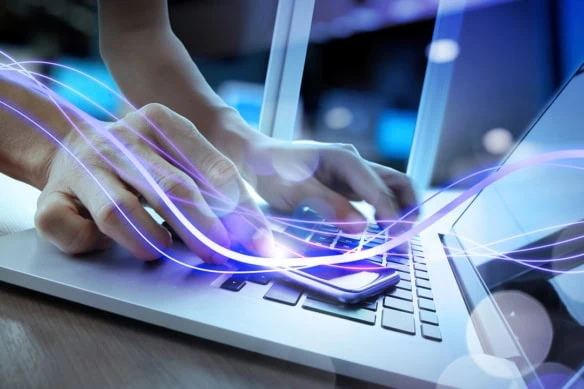 concept art of a purple light beam moving across a person's hand and onto their laptop.