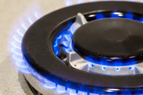 a gas stove burner with blue flames coming out of it.