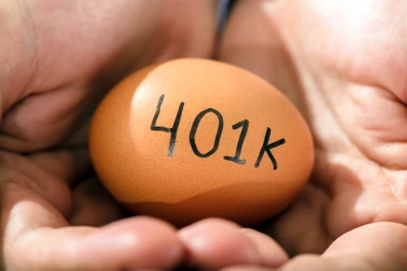 a person holding a brown egg that says 401k.