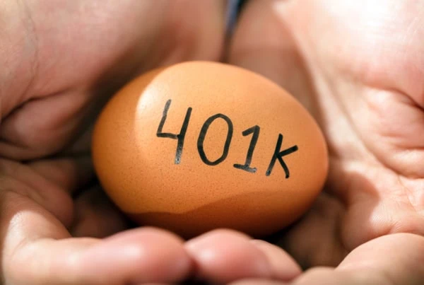 a person holding a brown egg that says 401k.