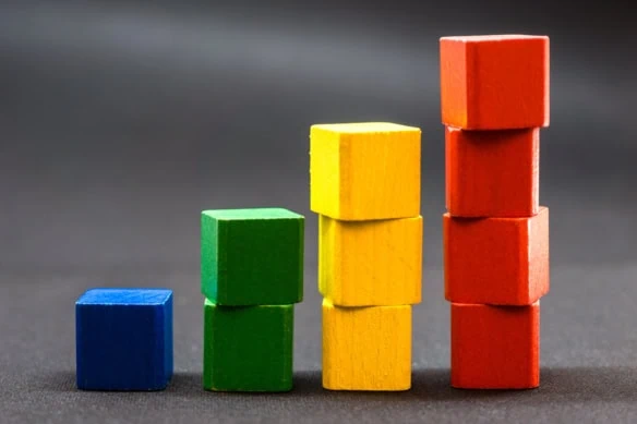 ascending piles of blue green yellow and red building blocks.