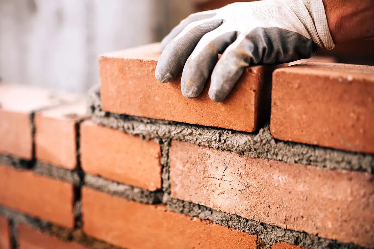 Here Are Vanguard's Best Portfolio 'Building Blocks' 2 a bricklayer sets a brick into mortar.