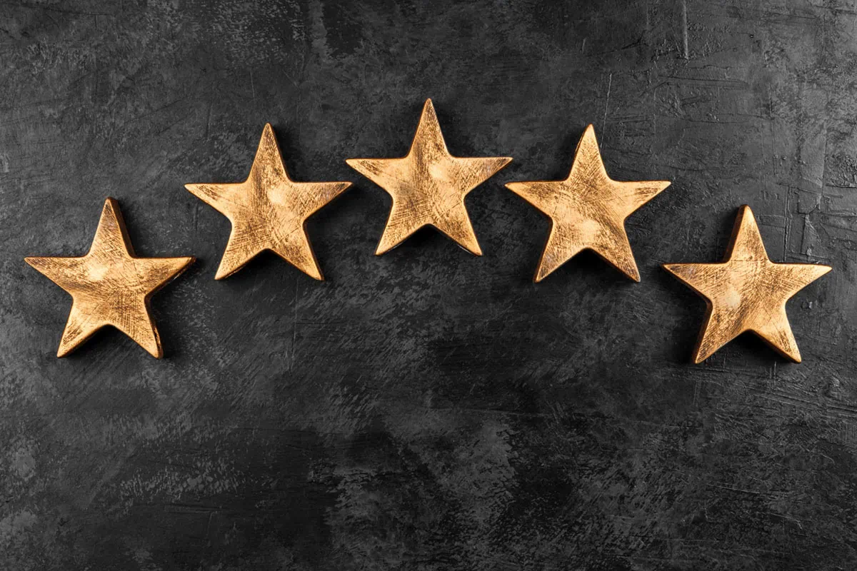 five wooden stars against a black background.
