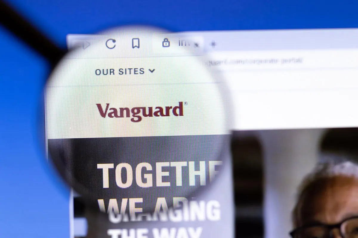 VTI or VOO: Which Vanguard Index Fund Should You Buy? 2 a closeup of vanguards website underneath a magnifying glass.