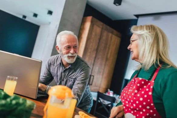 a happy retired couple spends time in the kitchen together.