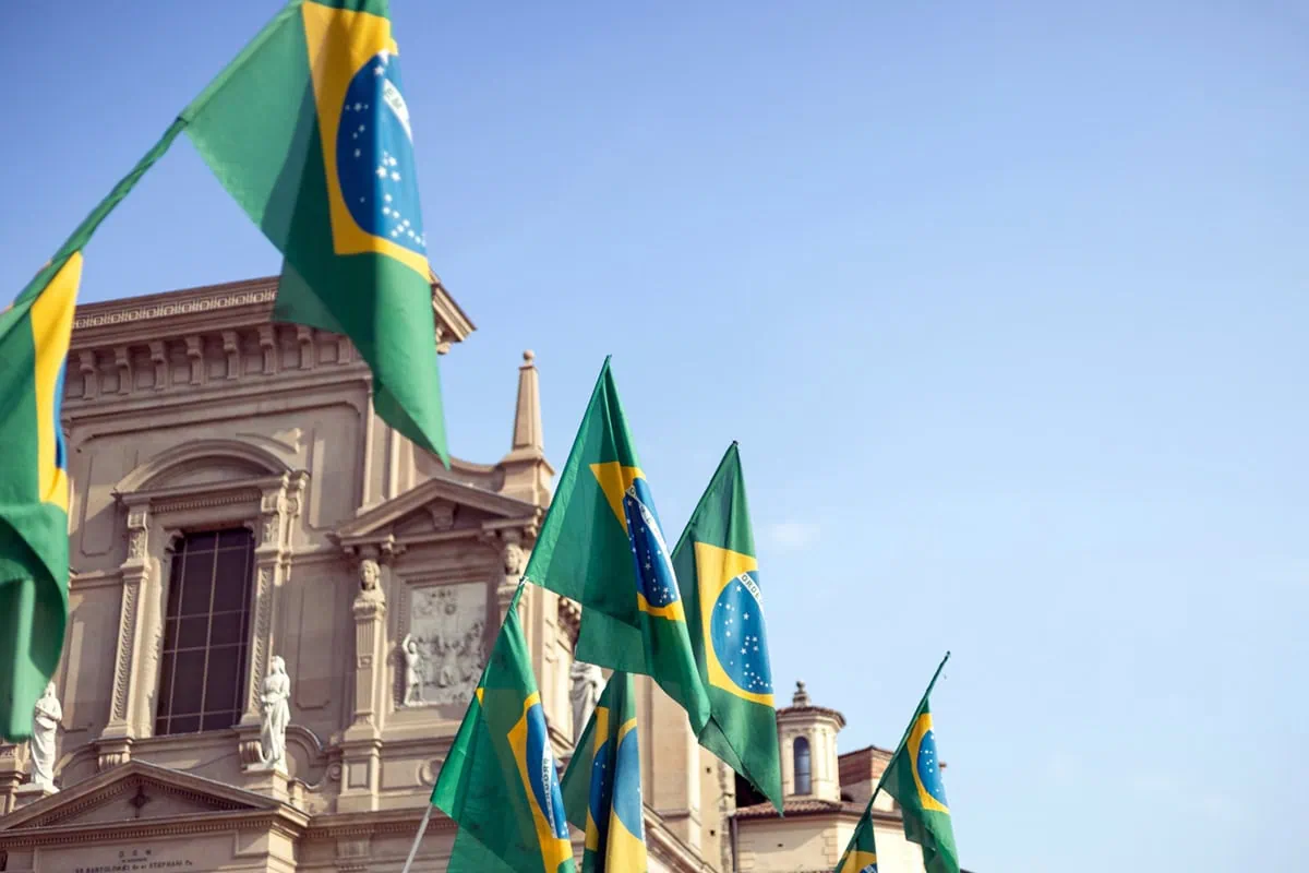 several brazil flags waving from a building.