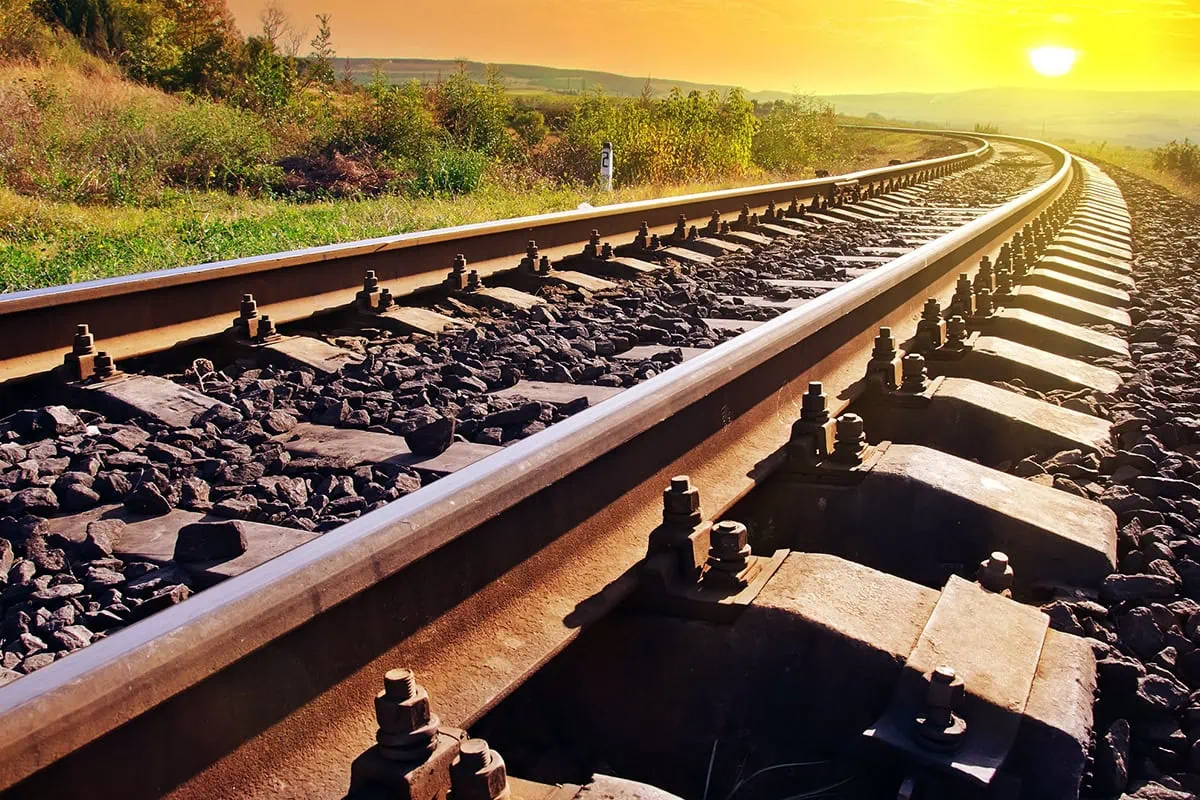 a stretch of railroad track at sunset.
