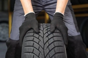 Car mechanic is preparing tire for change in garage.