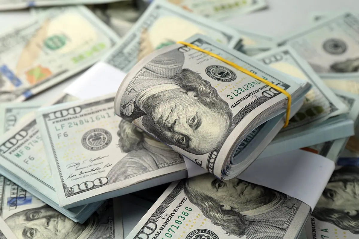 How Does the Cash Surrender Value of a Life Insurance Policy Work? 2 Many hundred dollar bills against a light background.