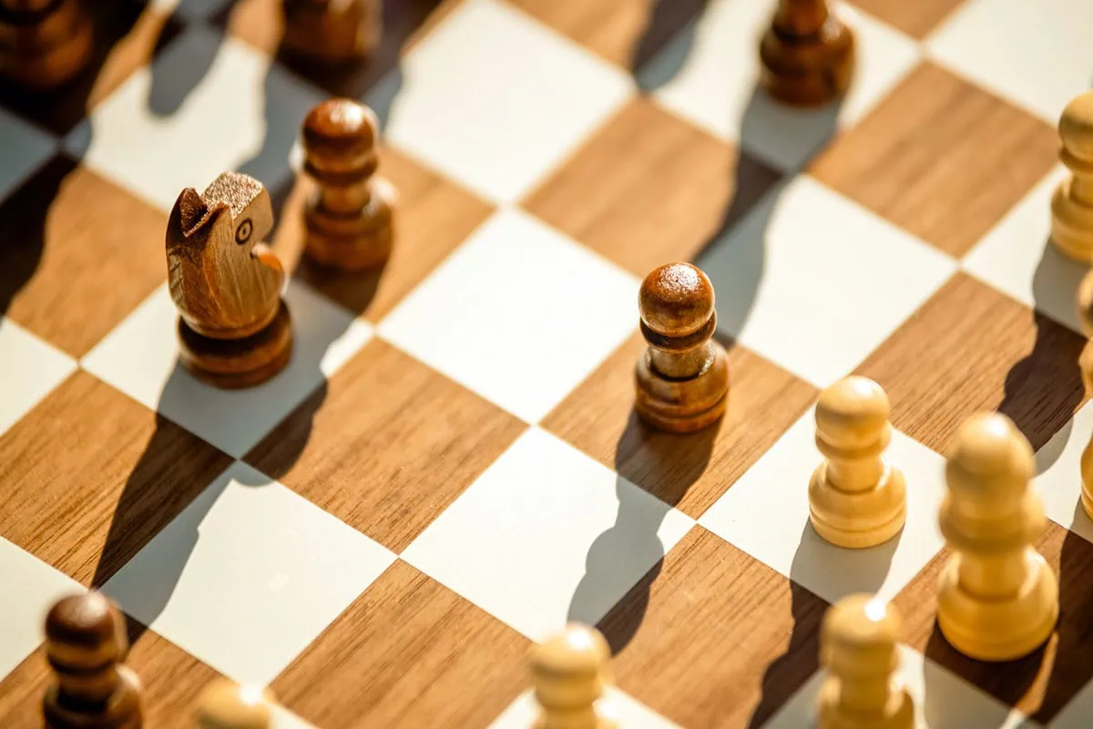 a small chess board with small chess pieces.
