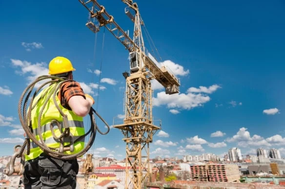 construction worker looks up toward crane