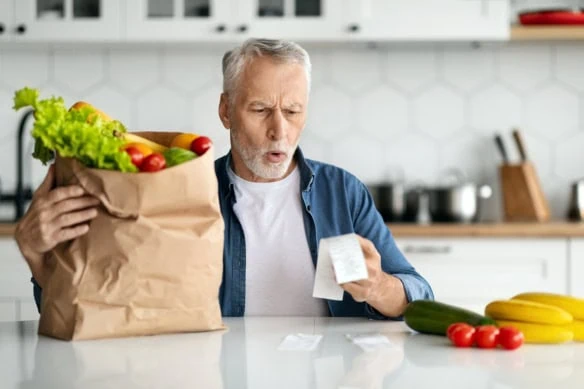 a man looks surprised at his grocery bill.