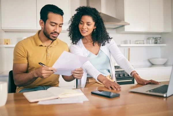 Couple, insurance paperwork and budget planning with laptop, bills and finance with taxes and mortgage. Financial documents, payment and loan with policy, audit and review with asset management.