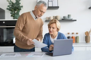 Portrait of focused senior couple looking at financial document