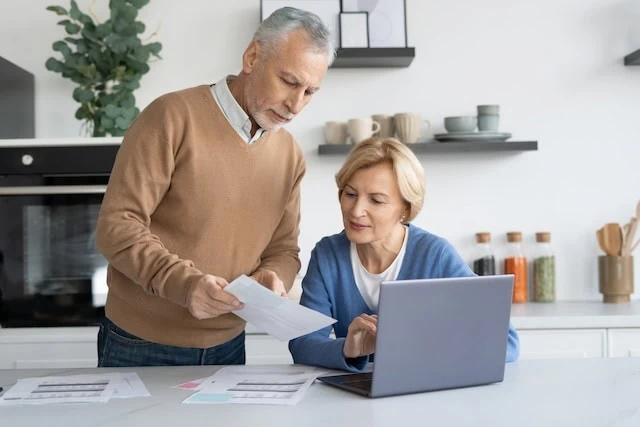 Portrait of focused senior couple looking at financial document