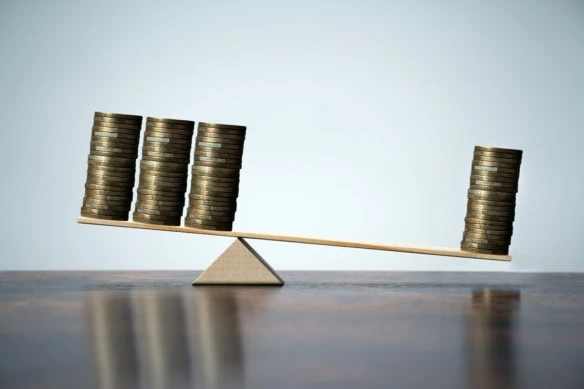 a balance with one stack of coins on one side and three stacks on the other.