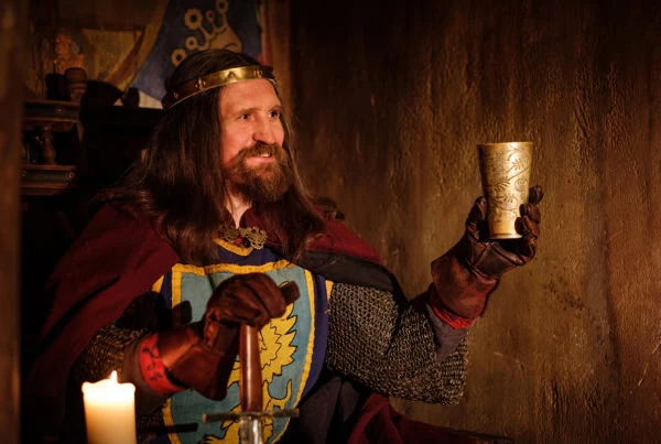 a king lifts his cup in celebration.