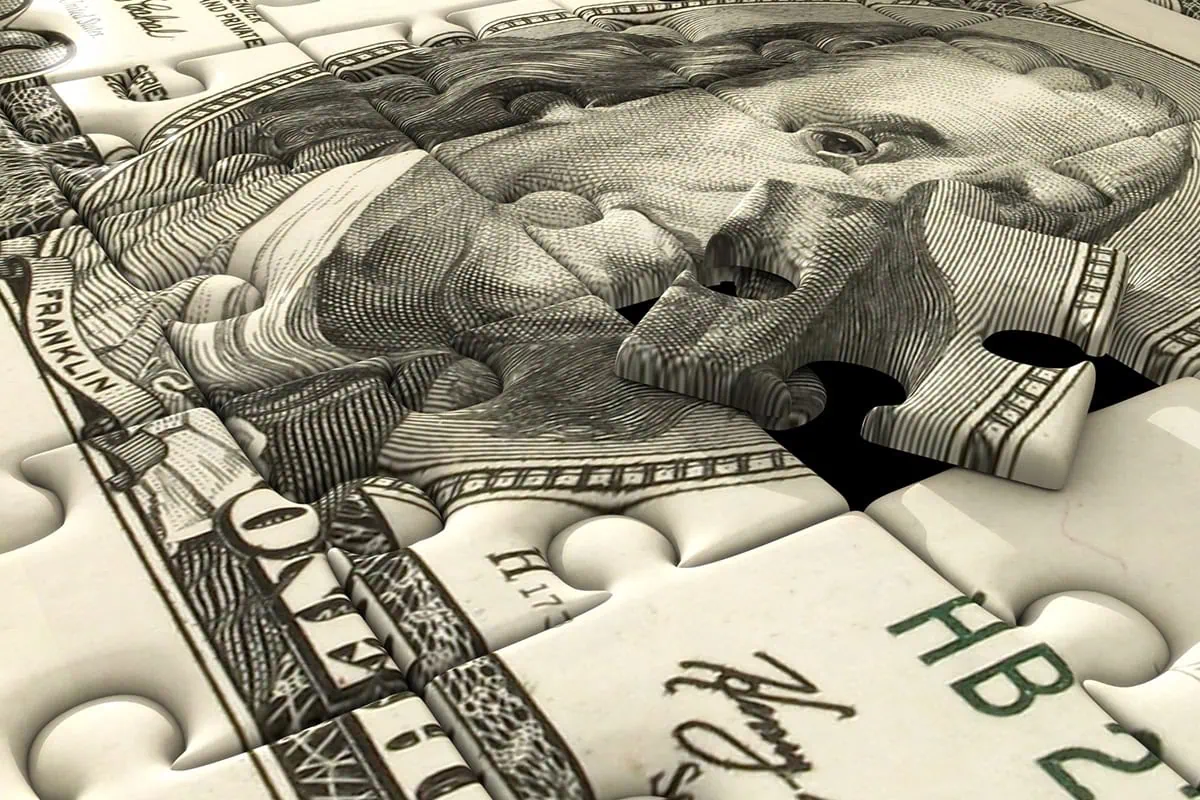 High Yield, Diversified: 7 ETFs That Pay Up to 10.7% 2 a dollar bill is cut into puzzle pieces.