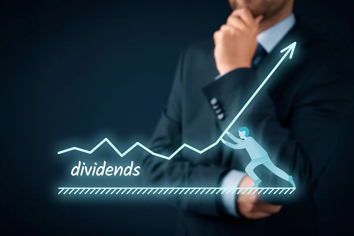 The Pros' 10 Favorite Dividend Aristocrats to Buy 2 a hologram of a charge showing dividend rising superimposed against a thinking businessman.