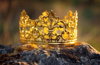 sunlight hits a golden crown sitting on a rock.