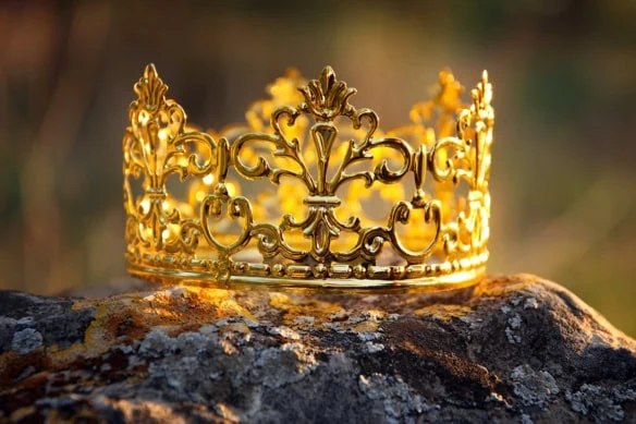 sunlight hits a golden crown sitting on a rock.