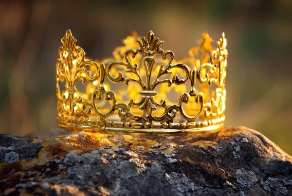 sunlight hits a golden crown sitting on a rock.