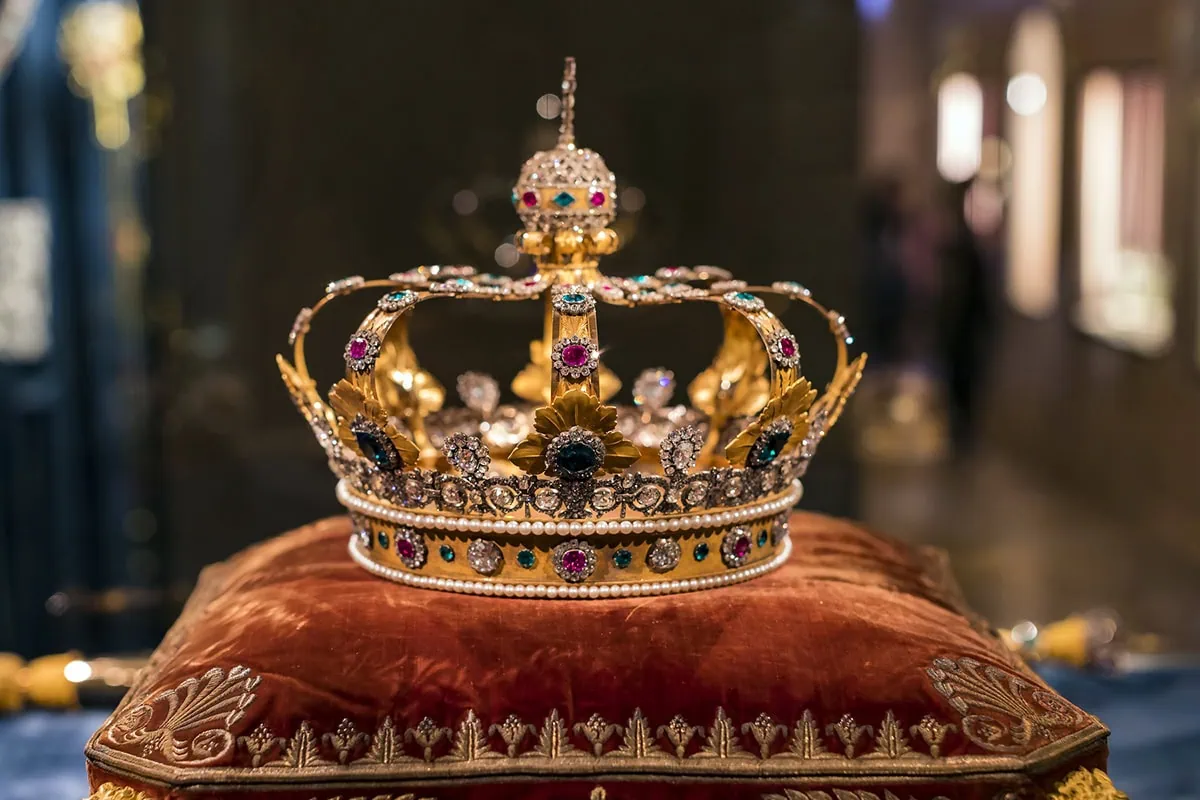 a crown rests upon a pillow.