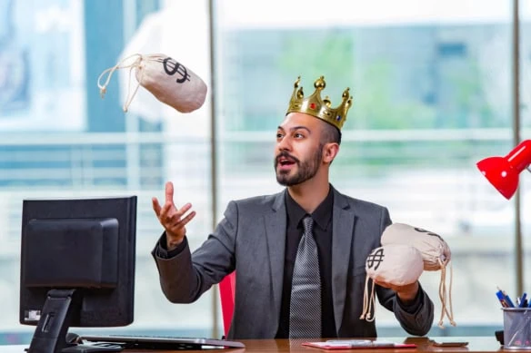 a businessman wearing a kings crown juggles little cloth bags of cash.