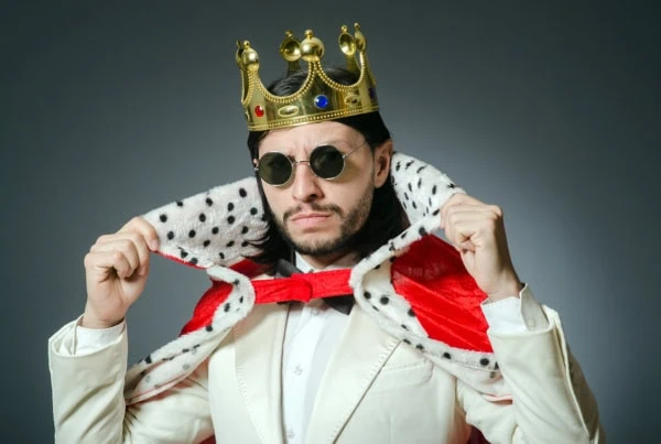 a man is dressed up both like a businessman and a king.
